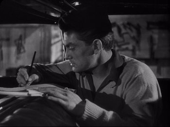 Movie still from “Orpheus” (1950), directed by Jean Cocteau – A black and white photo of a man writing on a piece of paper; Close Up shot, Low angle