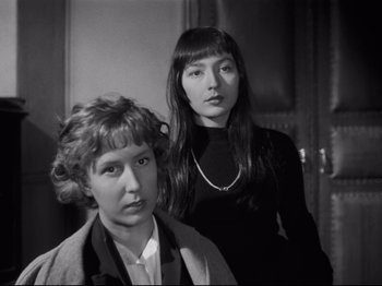 Movie still from “Orpheus” (1950), directed by Jean Cocteau – Two women standing next to each other in a room; Close Up shot, High angle