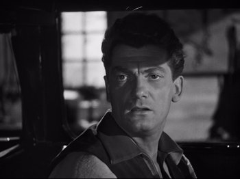 Movie still from “Orpheus” (1950), directed by Jean Cocteau – A black - and - white photo of a man looking at the camera; Close Up shot, Low angle