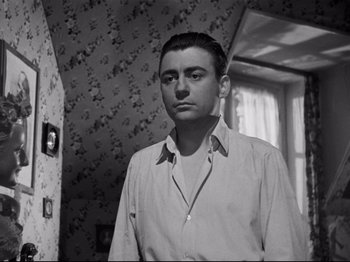 Movie still from “Orpheus” (1950), directed by Jean Cocteau – A black and white photo of a man standing in front of a window; Close Up shot, Low angle