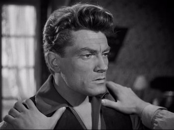 Movie still from “Orpheus” (1950), directed by Jean Cocteau – An old black and white photo of a man adjusting his tie; Close Up shot, Over the shoulder angle