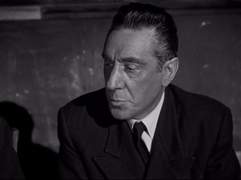 Movie still from “Orpheus” (1950), directed by Jean Cocteau – An old black and white photo of a man wearing a suit; Close Up shot, Low angle