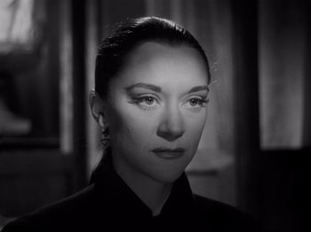 Movie still from “Orpheus” (1950), directed by Jean Cocteau – A black and white photo of a woman in a black shirt; Close Up shot, Low angle