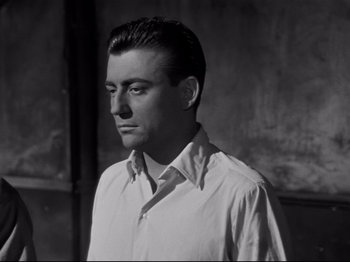 Movie still from “Orpheus” (1950), directed by Jean Cocteau – Black and white photograph of a man wearing a white shirt; Close Up shot, Low angle