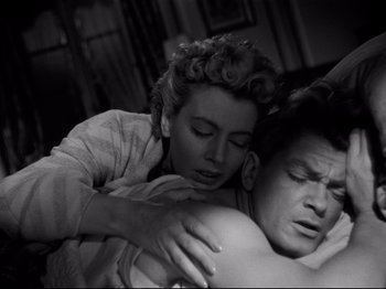 Movie still from “Orpheus” (1950), directed by Jean Cocteau – An old black and white photo of a man and a woman hugging; Medium shot, High angle