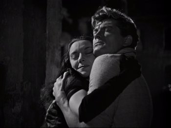 Movie still from “Orpheus” (1950), directed by Jean Cocteau – A man and a woman embracing each other in the dark; Medium shot, Low angle