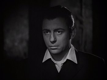 Movie still from “Orpheus” (1950), directed by Jean Cocteau – A black and white photo of a man in a suit; Close Up shot, Low angle