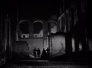 Movie still from “Orpheus” (1950), directed by Jean Cocteau – A group of people standing in an abandoned building; Extreme Wide shot, Low angle