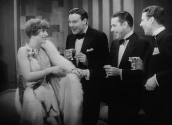 Movie still from “Our Dancing Daughters” (1928), directed by Harry Beaumont – A group of men and a woman in formal wear drinking champagne; Medium shot, High angle