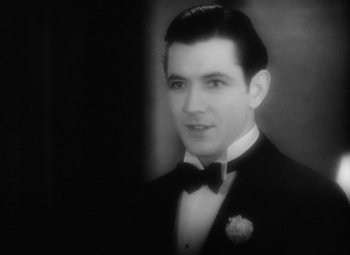 Movie still from “Our Dancing Daughters” (1928), directed by Harry Beaumont – A man in a suit and bow tie in front of a mirror; Close Up shot, High angle