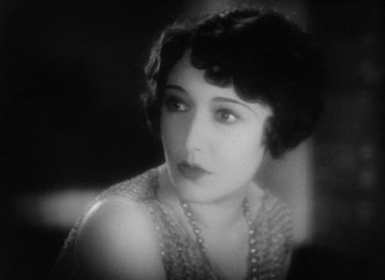 Movie still from “Our Dancing Daughters” (1928), directed by Harry Beaumont – An old photo of a woman in a white dress; Close Up shot, High angle