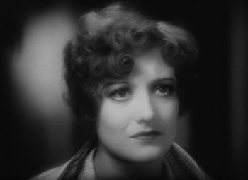 Movie still from “Our Dancing Daughters” (1928), directed by Harry Beaumont – An old photo of an older woman with curly hair; Close Up shot, High angle