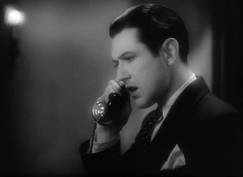 Movie still from “Our Dancing Daughters” (1928), directed by Harry Beaumont – A black and white photo of a man talking on a phone; Close Up shot, High angle