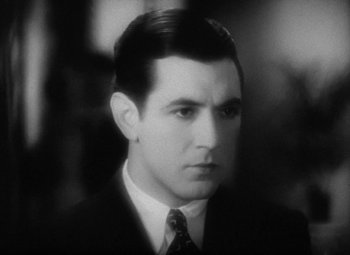 Movie still from “Our Dancing Daughters” (1928), directed by Harry Beaumont – A black and white photo of a man in a suit and tie; Close Up shot, High angle