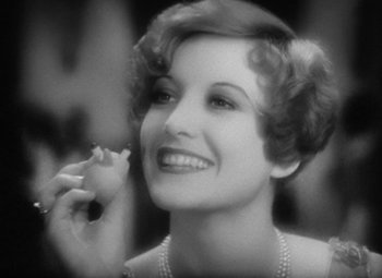 Movie still from “Our Dancing Daughters” (1928), directed by Harry Beaumont – An old photo of a woman holding a piece of food; Close Up shot, Low angle