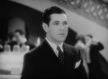 Movie still from “Our Dancing Daughters” (1928), directed by Harry Beaumont – A black and white photo of a man in a suit and tie; Close Up shot, High angle
