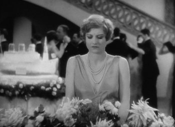 Movie still from “Our Dancing Daughters” (1928), directed by Harry Beaumont – An old photo of a woman holding a bouquet of flowers; Medium shot, High angle