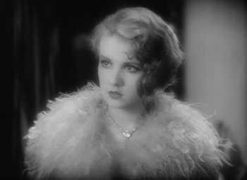 Movie still from “Our Dancing Daughters” (1928), directed by Harry Beaumont – A black - and - white photo of a woman wearing a feather boa; Close Up shot, Over the shoulder angle