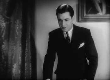 Movie still from “Our Dancing Daughters” (1928), directed by Harry Beaumont – A black and white photo of a man in a suit and tie; Medium shot, Low angle