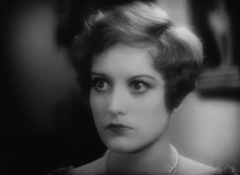 Movie still from “Our Dancing Daughters” (1928), directed by Harry Beaumont – An old photo of a woman with a pearl necklace; Close Up shot, High angle