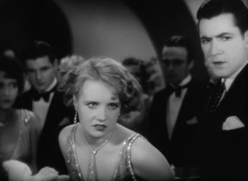 Movie still from “Our Dancing Daughters” (1928), directed by Harry Beaumont – A black and white photo of a woman in a dress; Medium shot, Low angle