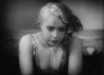Movie still from “Our Dancing Daughters” (1928), directed by Harry Beaumont – A young woman wearing a dress with a necklace around her neck; Close Up shot, High angle