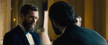 Movie still from “Our Kind of Traitor” (2016), directed by Susanna White – A man in a suit and tie talking to another man in a suit and tie; Close Up shot, Over the shoulder angle