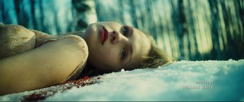 Movie still from “Our Kind of Traitor” (2016), directed by Susanna White – A girl laying in the middle of a snow covered field; Close Up shot, Low angle