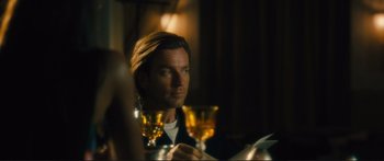 Movie still from “Our Kind of Traitor” (2016), directed by Susanna White – A man sitting at a table with a glass of wine; Close Up shot, Over the shoulder angle