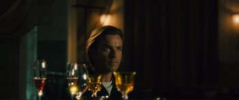 Movie still from “Our Kind of Traitor” (2016), directed by Susanna White – A man sitting in front of a bunch of wine glasses; Close Up shot, Over the shoulder angle