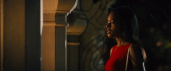 Movie still from “Our Kind of Traitor” (2016), directed by Susanna White – A woman in a red dress is standing by a wall; Medium shot, Low angle