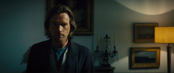 Movie still from “Our Kind of Traitor” (2016), directed by Susanna White – A man with long brown hair wearing a black jacket; Close Up shot, Low angle