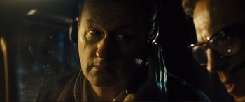 Movie still from “Our Kind of Traitor” (2016), directed by Susanna White – A person wearing headphones and talking on a cell phone; Close Up shot, Overhead angle