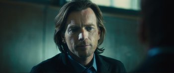 Movie still from “Our Kind of Traitor” (2016), directed by Susanna White – A person wearing a suit and tie; Close Up shot, Over the shoulder angle
