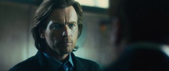 Movie still from “Our Kind of Traitor” (2016), directed by Susanna White – A person wearing a suit and tie; Close Up shot, Over the shoulder angle