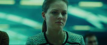 Movie still from “Our Kind of Traitor” (2016), directed by Susanna White – A young woman with long dark hair wearing a black and white top; Close Up shot, Low angle