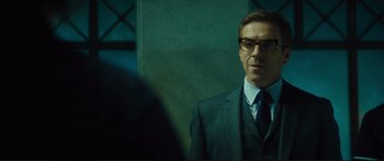Movie still from “Our Kind of Traitor” (2016), directed by Susanna White – A man in a suit and tie looking at a mirror; Close Up shot, Over the shoulder angle