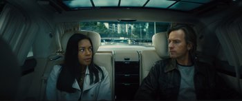 Movie still from “Our Kind of Traitor” (2016), directed by Susanna White – A man and a woman sitting in the back of a car; Medium shot, Over the shoulder angle