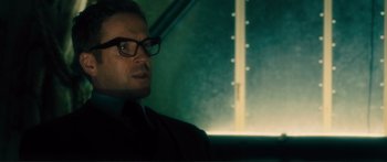 Movie still from “Our Kind of Traitor” (2016), directed by Susanna White – A person wearing a suit and glasses; Close Up shot, Over the shoulder angle