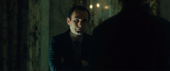 Movie still from “Our Kind of Traitor” (2016), directed by Susanna White – A man wearing a suit and tie looking at a mirror; Close Up shot, Over the shoulder angle