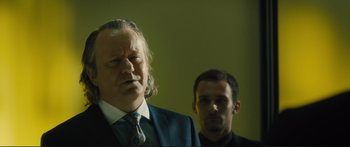 Movie still from “Our Kind of Traitor” (2016), directed by Susanna White – A man in a suit standing next to another man in a suit; Close Up shot, Low angle