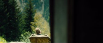 Movie still from “Our Kind of Traitor” (2016), directed by Susanna White – A woman sitting in a chair looking out a window; Wide shot, Over the shoulder angle
