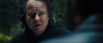 Movie still from “Our Kind of Traitor” (2016), directed by Susanna White – An older man with long grey hair stares into the camera; Close Up shot, Over the shoulder angle