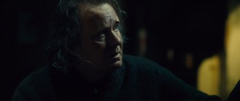 Movie still from “Our Kind of Traitor” (2016), directed by Susanna White – An older man looking into the distance in the dark; Close Up shot, Over the shoulder angle