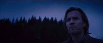 Movie still from “Our Kind of Traitor” (2016), directed by Susanna White – A man standing in front of trees at night; Close Up shot, Low angle