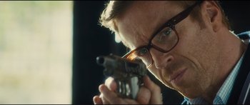 Movie still from “Our Kind of Traitor” (2016), directed by Susanna White – A person holding a gun; Close Up shot, Low angle