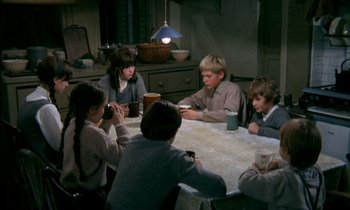 Movie still from “Our Mother's House” (1967), directed by Jack Clayton – A group of people sitting around a table; Medium shot, High angle