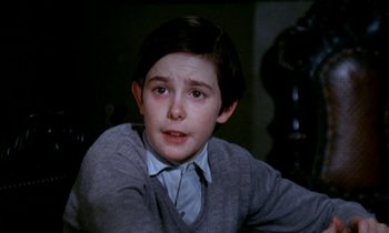 Movie still from “Our Mother's House” (1967), directed by Jack Clayton – A young boy in a grey sweater looking at the camera; Close Up shot, High angle