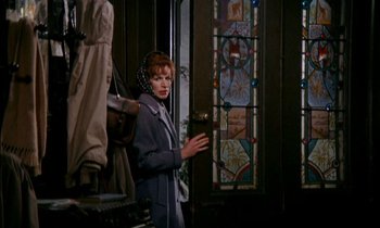 Movie still from “Our Mother's House” (1967), directed by Jack Clayton – A woman standing in front of a stained glass window; Medium shot, Low angle
