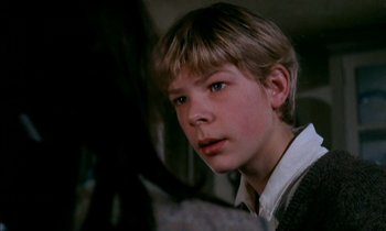 Movie still from “Our Mother's House” (1967), directed by Jack Clayton – A young boy with blonde hair and blue eyes looking at the camera; Close Up shot, Over the shoulder angle